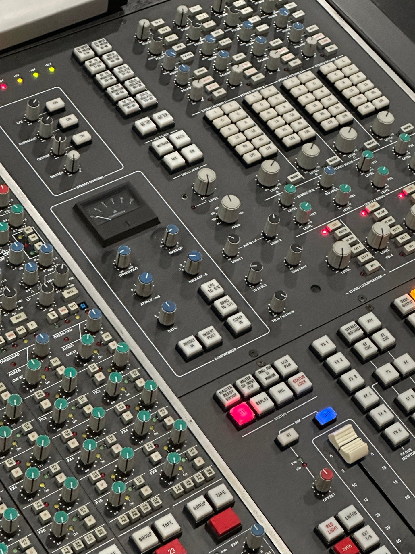 Close-up of a control panel with various buttons and sliders on a dark background