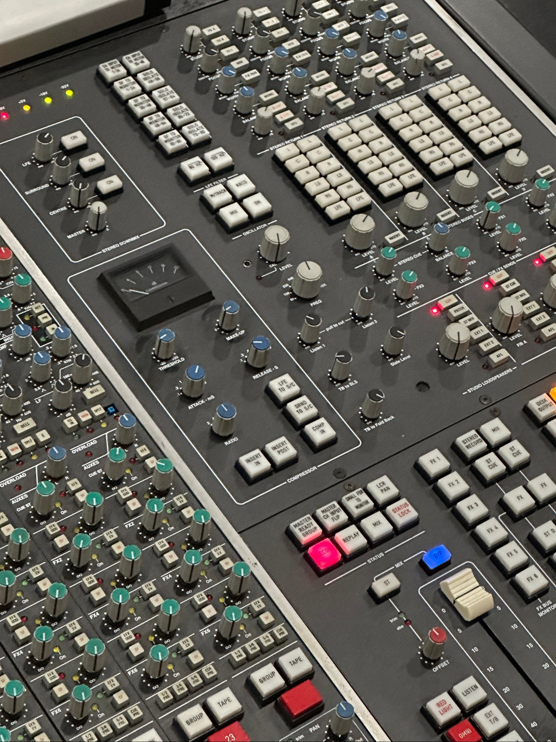 Close-up of a control panel with various buttons and sliders on a dark background