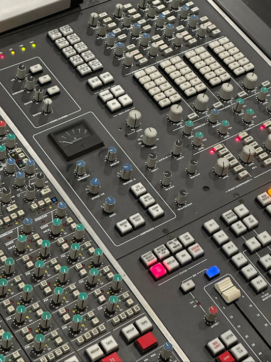 Close-up of a control panel with various buttons and sliders on a dark background